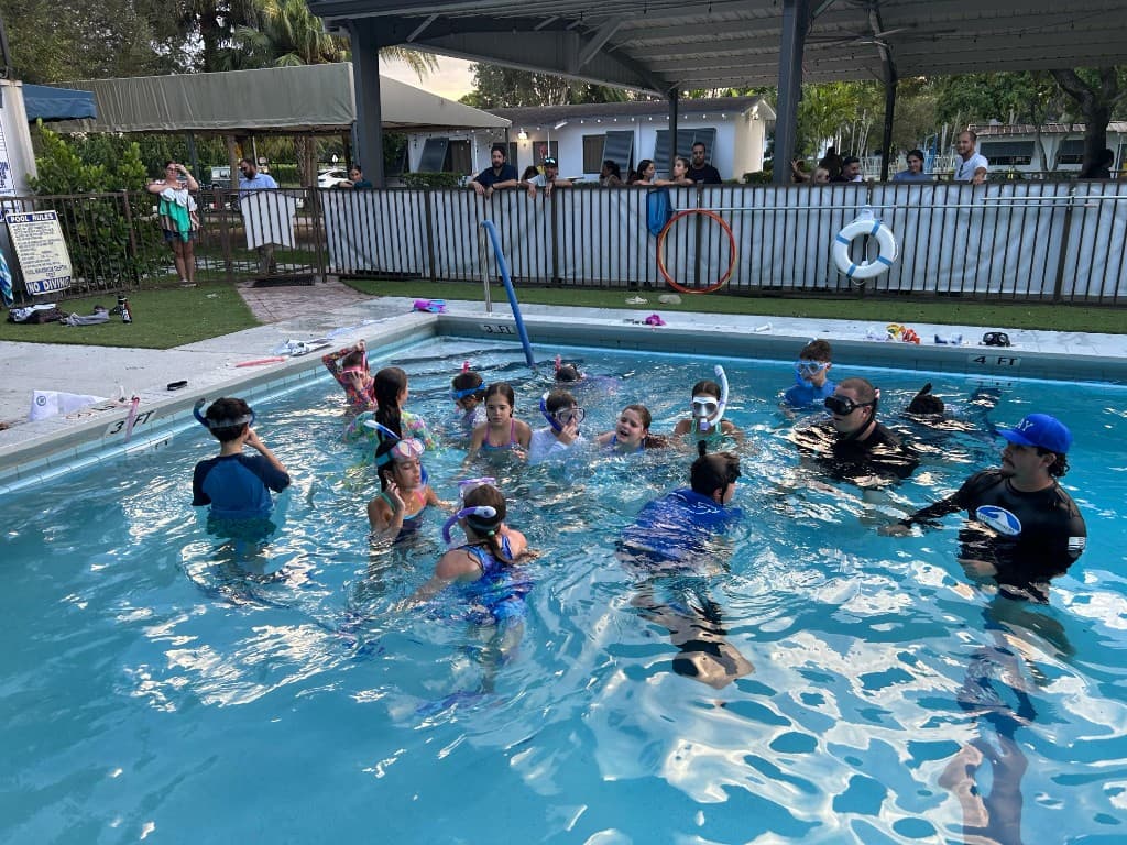 Children in snorkeling class with instructors in the pool